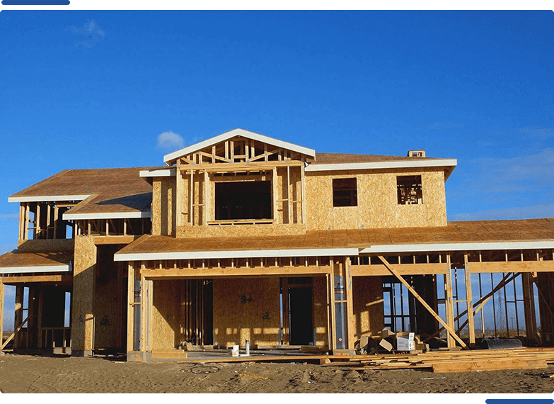 A house under construction with blue sky in the background.